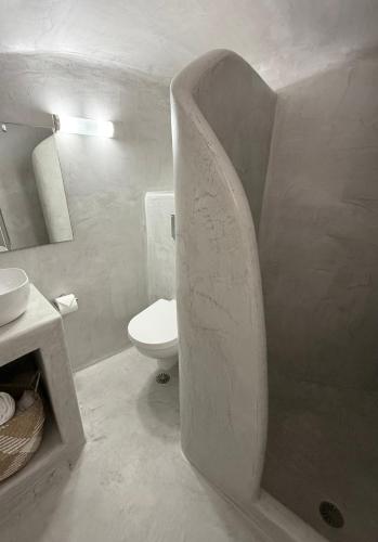 a white bathroom with a toilet and a sink at Fira Value Rooms- Fira Center- Capital Santorini in Fira
