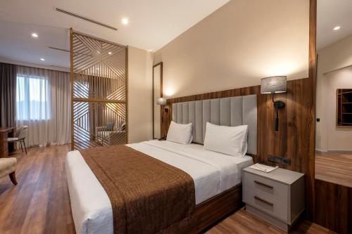 a hotel room with a bed and a chair at White Hill Hotel in Tbilisi City
