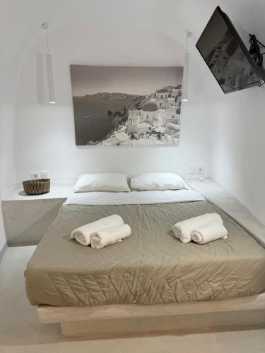 a bedroom with two white towels on a bed at Fira Value Rooms- Fira Center- Capital Santorini in Fira
