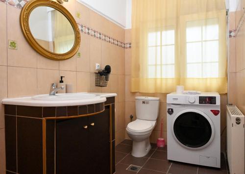 a bathroom with a toilet and a washing machine at Sunrise Horizon in Iraklitsa