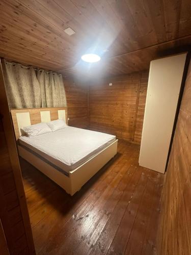 a bedroom with a bed in a wooden room at carmel cabins suite 3 in Yājur