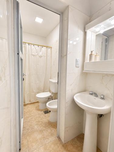 a bathroom with two toilets and a sink and a mirror at Paramont Rosario 2 in Rosario de la Frontera