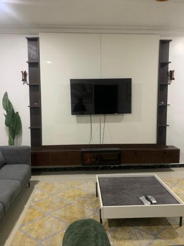 a living room with a flat screen tv on a wall at Beacon Shortlet in Kaduna