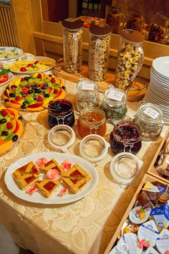 a table topped with plates of food and desserts at Hotel Serena - Tre Cime Views in Auronzo di Cadore