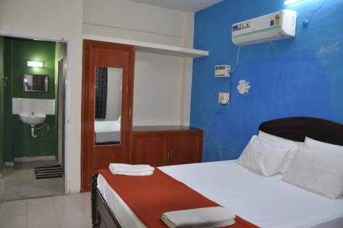 a bedroom with a bed and a bathroom with a air conditioner at Haritha Apartments Family-Only Apartments in Tirupati, Big Families, Groups Welcome in Tirupati