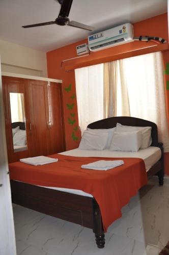 a bedroom with a bed with a red blanket at Haritha Apartments Family-Only Apartments in Tirupati, Big Families, Groups Welcome in Tirupati