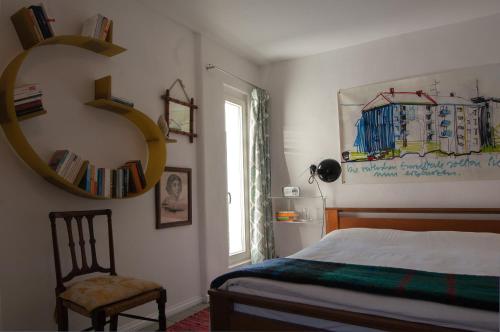 a bedroom with a bed and a chair and a mirror at trouve ferienwohnung in Doberlug-Kirchhain