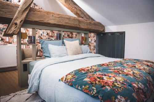 a bedroom with a large bed with a floral blanket at Maison Vitis in Fuissé