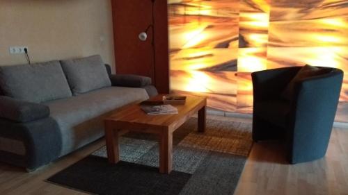 a living room with a couch and a coffee table at Pension Malu die hundefreundliche Pension mit Frühstück ab 6 Uhr in Todenbüttel