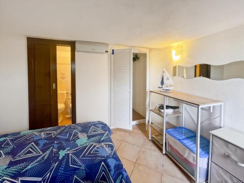 a small bedroom with a bed and a desk at Villetta La Risacca - fronte mare - seafront in Costa Paradiso