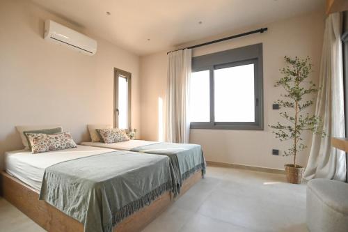 a bedroom with two beds and a window at Villa Ino in Myrties
