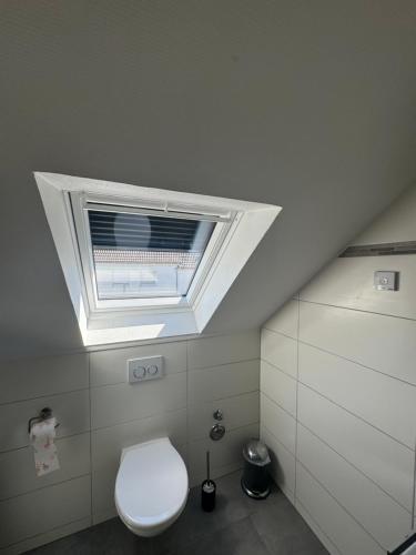 a bathroom with a toilet and a window at Corinnas Ferienwohnung in Büdingen