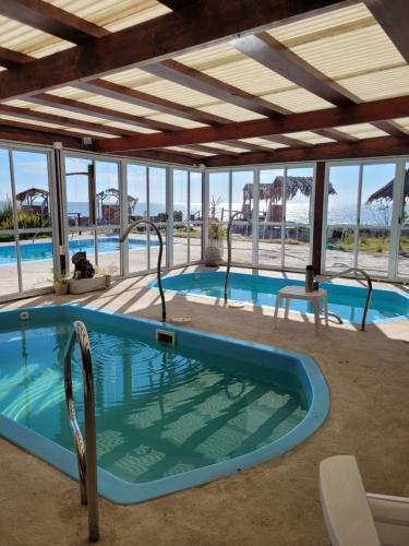 a large swimming pool with a large building with windows at Punta Encanto Posada Boutique in Miramar