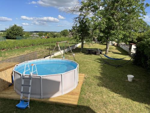 a bath tub sitting on a wooden deck next to a tree at Gîte Chez Paddy in Ladoix Serrigny