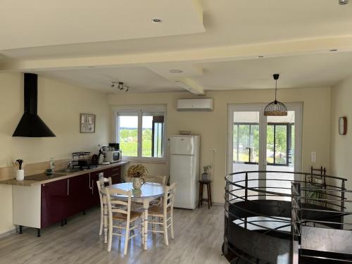 a kitchen and living room with a table and chairs at Gîte Chez Paddy in Ladoix Serrigny