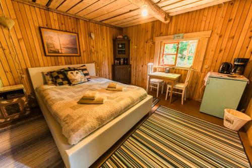 ein Schlafzimmer mit einem Bett in einer Holzhütte in der Unterkunft Old Silent in Hara