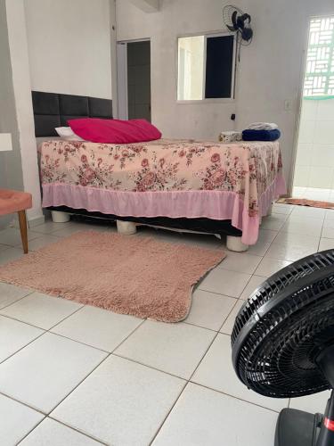 a bedroom with a bed with a pink blanket and a mirror at FLAT ZONA NORTE NATAL PRÓX PRAIA GENIPABU ou shopping partage in Natal