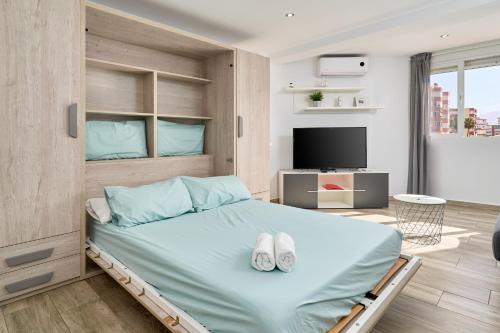 a bedroom with a bed with two white shoes on it at Estudio Plazamar Palace in Torre del Mar