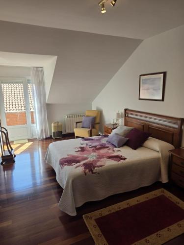 a bedroom with a large bed and a chair at Casa el Bosque in Camargo