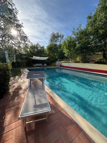 a swimming pool with a table next to it at La Loggia di Montefienali in Gaiole in Chianti