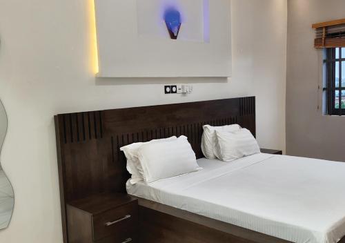 a bed with white sheets and pillows in a room at Appartement de Deux chambres Salon à Ouando - SKYFORCE Bénin in Porto-Novo