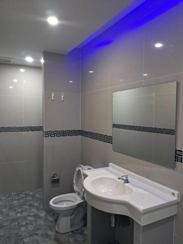 a bathroom with a sink and a toilet and a mirror at Sleek Modern Studio in Rawai, Phuket in Ban Saiyuan (1)