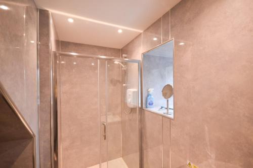a bathroom with a shower with a glass door at The Smithy at 52 Vatisker in Stornoway