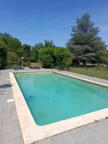 a large swimming pool with blue water at Chambre chez l'habitant les garrigues in Piolenc
