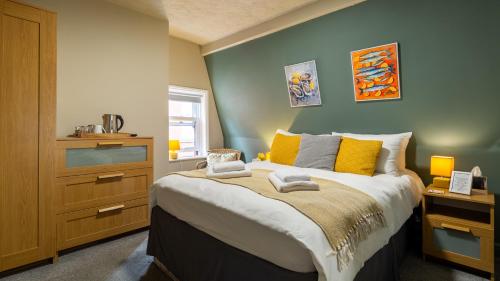 a bedroom with a large bed with yellow pillows at The Granby Hotel in Whitby
