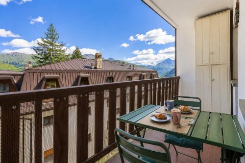 a table and chairs on a balcony with a view at Hostdomus - Clotes 33 in Sauze d'Oulx