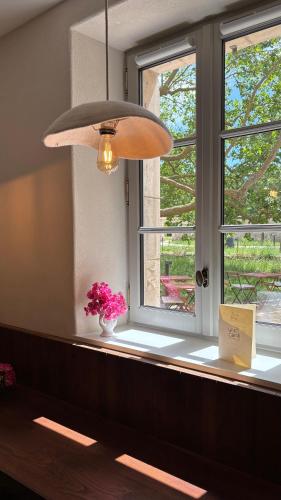 a pendant light hanging over a bench next to a window at Coureilles Appartements et Suites in La Rochelle