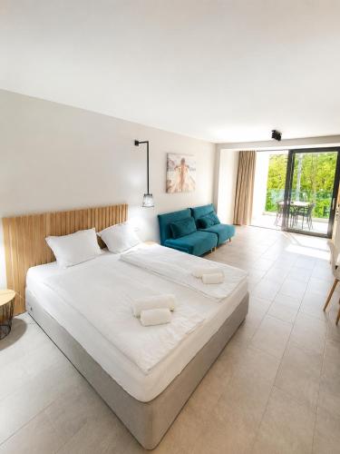 a bedroom with a large bed and a blue couch at Teracite in Varna City