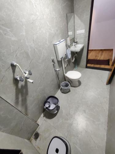 a bathroom with a toilet and a sink at Kanakdhara farmhouse in Ujjain