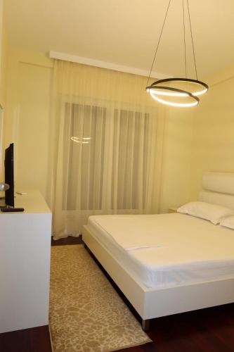 a bedroom with a white bed and a window at Vila 26, Lura 2, Gjiri i Lalezit in Ishëm