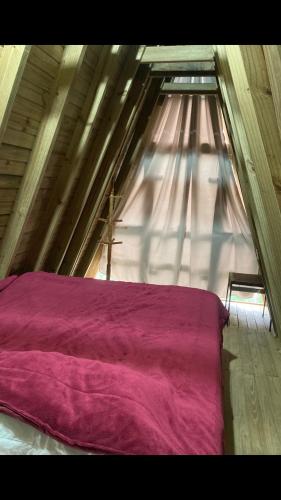 a bedroom with a large window with a purple bed at Paraitinga Glamping in São Luiz do Paraitinga