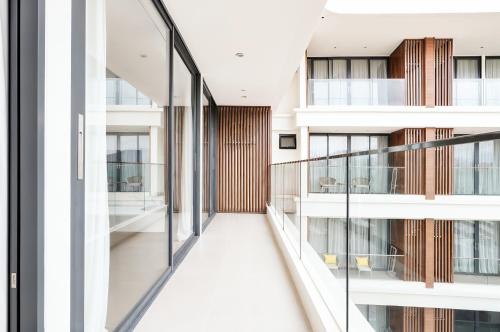 an internal corridor of a building with glass balconies at Beachfront Luxury Apartment Bangtao Phuket in Bang Tao Beach