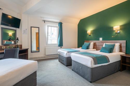 a hotel room with two beds and a desk at Castlefield Hotel in Manchester