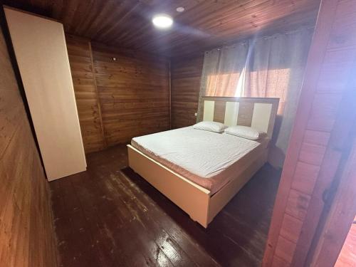 a bedroom with a bed in a wooden room at carmel cabins suite 4 in ‘Isfiyā