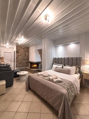 una camera da letto con un grande letto e un camino di Ampolis Guest House ad Aráchova