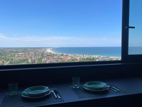 a table with two plates and a view of the ocean at Suite 26 Rimini in Rimini