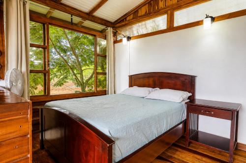 a bedroom with a bed and a large window at Cabañas Bella Vista in Hojancha