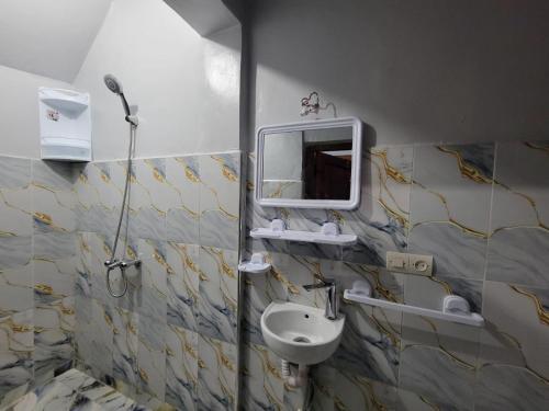 a bathroom with a sink and a mirror at Villa RAHA villa entière in El Aggada