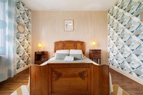 a bedroom with a wooden bed with two pillows at Maison de vacances La Couade in Troche