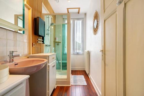 a bathroom with a sink and a glass shower at Maison de vacances La Couade in Troche