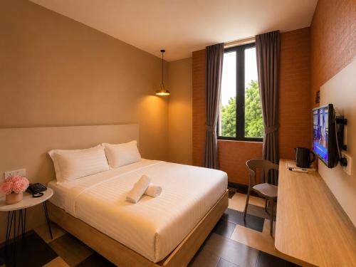 a hotel room with a bed and a tv at the youniQ Hotel, KLIA T1, KLIA T2 in Sepang