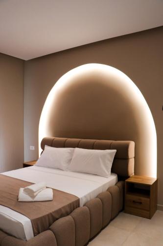 a bedroom with a large bed with an arch above it at Hotel Alga Velipoje in Velipojë