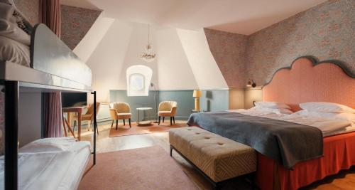 a bedroom with a large bed and a dining room at Hotel Kung Carl, WorldHotels Crafted in Stockholm