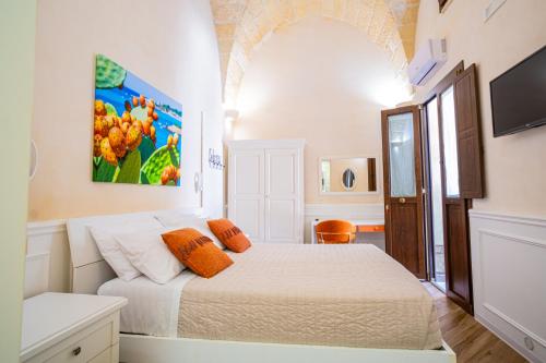 a bedroom with a bed and a flat screen tv at Salento Ada's House in Melendugno