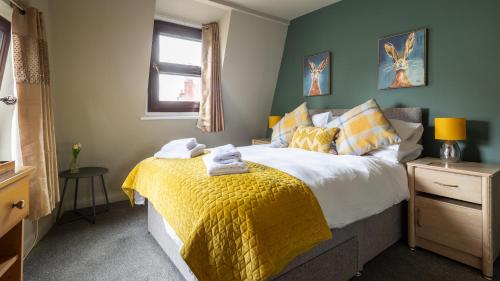 a bedroom with a bed with a yellow blanket at The Granby Hotel in Whitby
