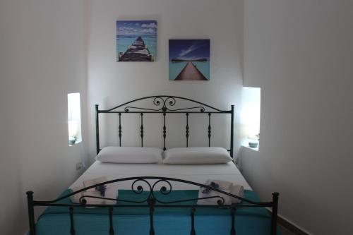 a bed in a bedroom with two pictures on the wall at Casa Briseida in Baia Verde